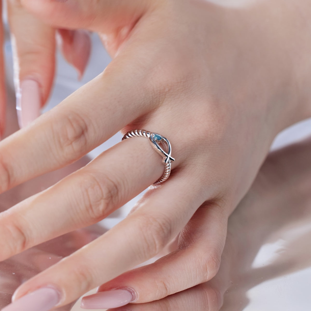 vista cercana del mano de una mujer lleva el Anillo Diseño Pez con Piedra Azul Turquesa de color plata